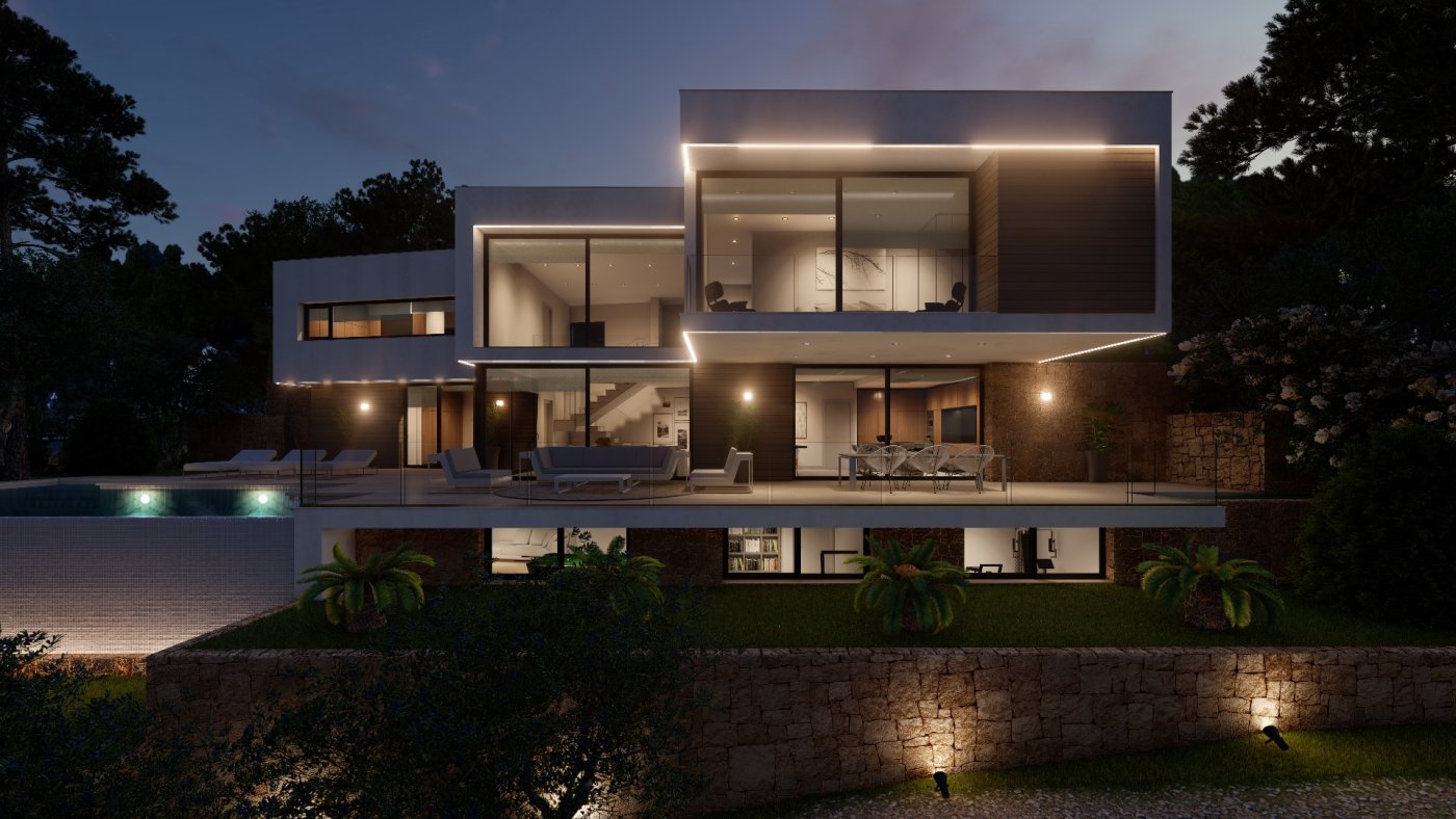 Villa moderna de varios niveles al anochecer con iluminación LED integrada, fachadas de cristal, terraza con muros de piedra y mobiliario exterior frente al jardín.