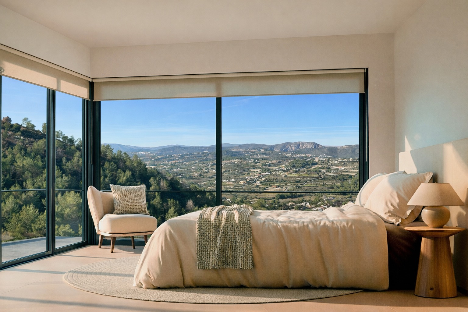 Dormitorio con ventanales de suelo a techo y vistas panorámicas al valle y las montañas. Incluye tonos neutros, mesita de madera y abundante luz natural.