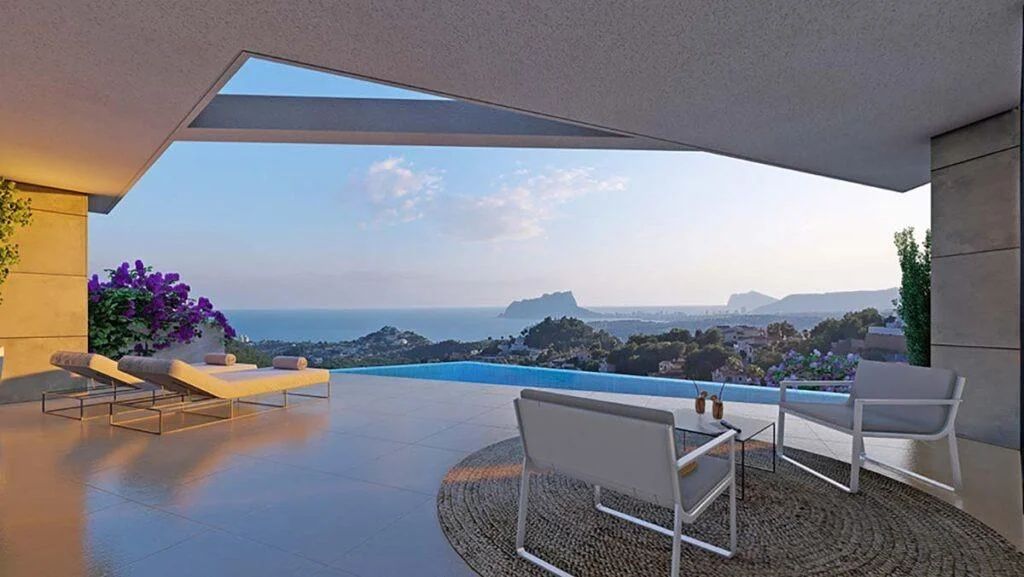 Terraza cubierta con piscina infinita y vistas panorámicas al mar Mediterráneo y al Peñón de Ifach. Incluye tumbonas y zona de estar sobre suelo de gres porcelánico.