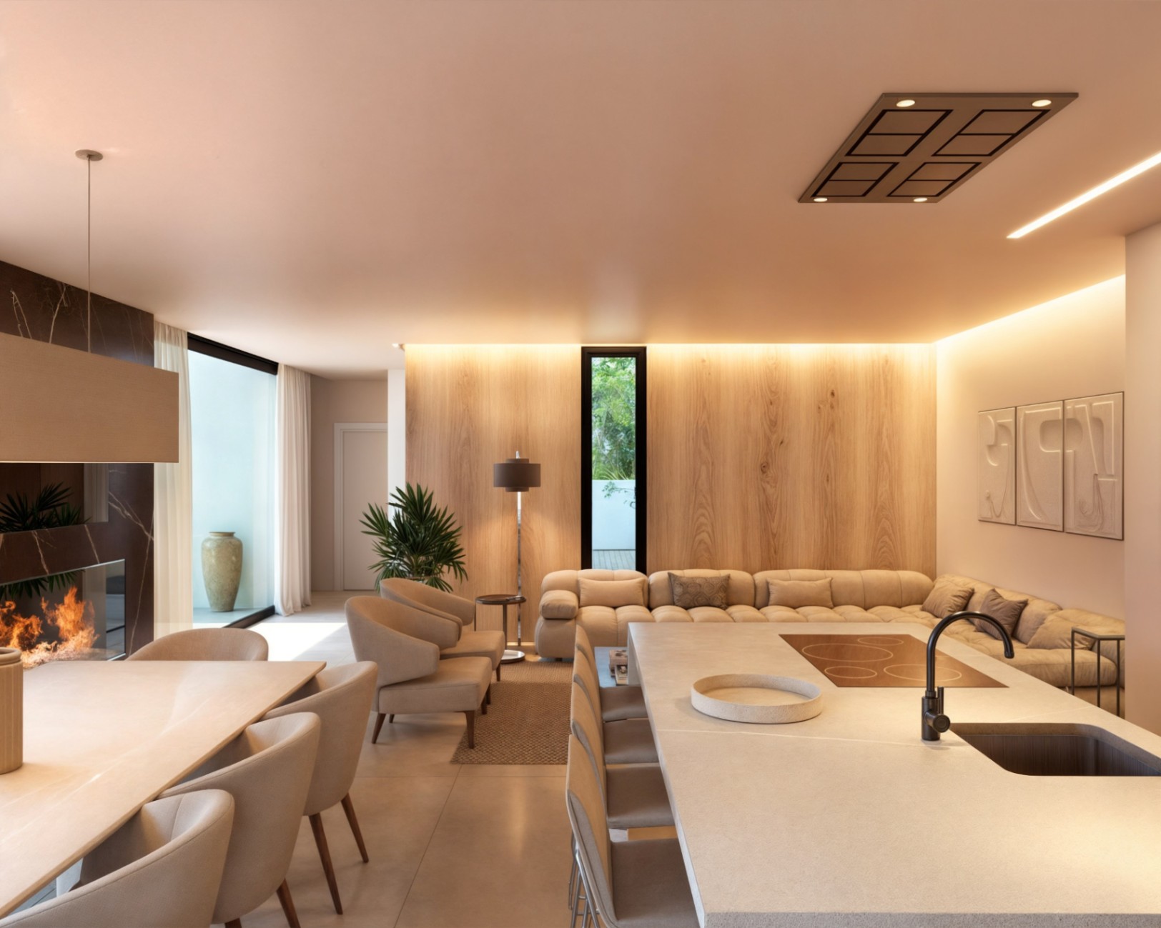 Espacio diáfano con isla de cocina de piedra, comedor con chimenea de mármol y salón con paredes paneladas en madera e iluminación indirecta.