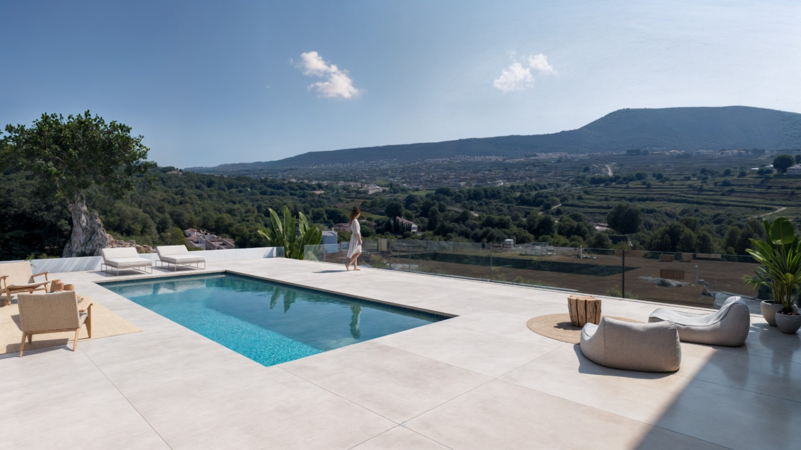 Terraza elevada con piscina rectangular, pavimentos de piedra de gran formato y barandillas de cristal con vistas al valle y el entorno montañoso.