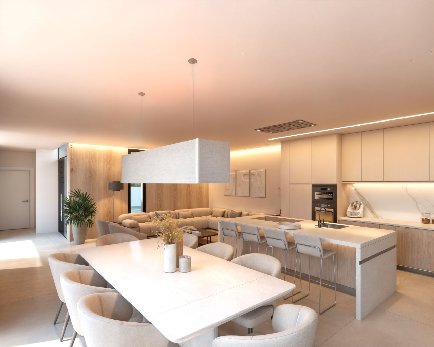 Zona de estar de concepto abierto con isla de cocina en cascada, electrodomésticos integrados y comedor con gran lámpara textil y paredes paneladas en madera.