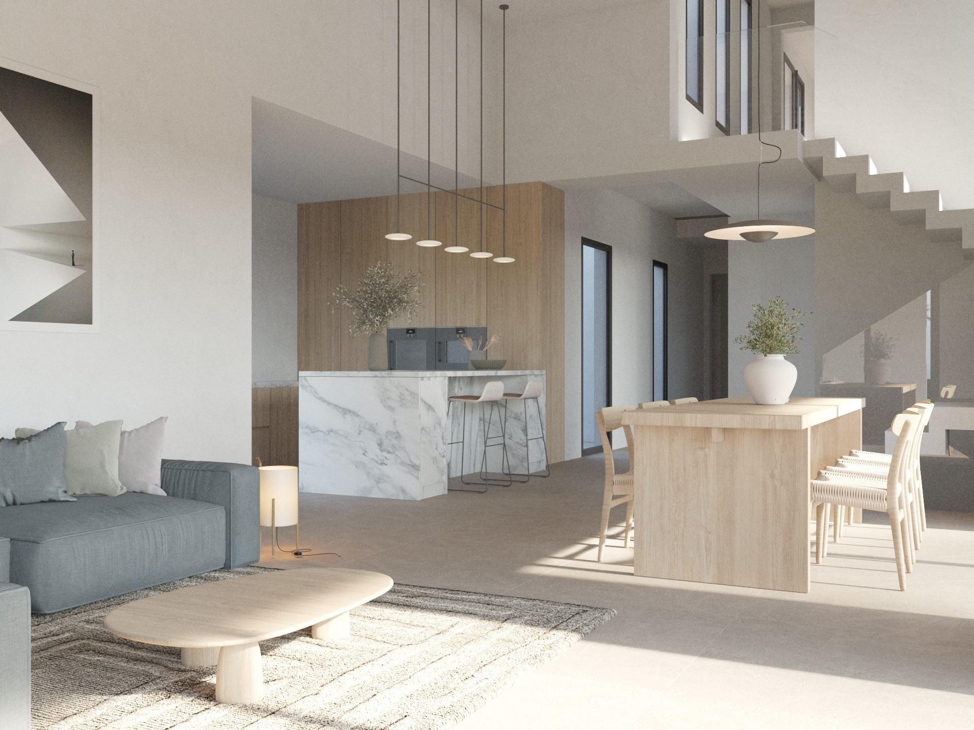Espacio diáfano con isla de cocina de mármol, comedor de madera y salón contemporáneo con sofá azul grisáceo y escalera minimalista integrada.